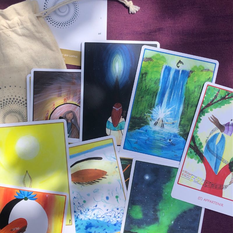Cartes Révelle illustrées par Lorina, oracle féminin étalé au soleil montrant la diversité des couleurs et des messages pour la conscience des cycles.